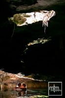 *
Sunlight streaming over cenote couple's embrace
