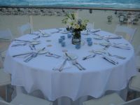 The hotel provided white linens and silverware. The staff took our sand dollars from the beach and placed them at each setting along with our wedding favor candles we brought. We also ordered tabletop floral centerpieces at an extra charge.